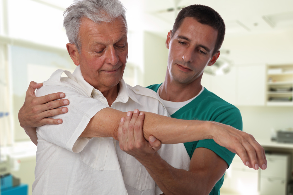 Man receiving physical therapy after complete shoulder replacement