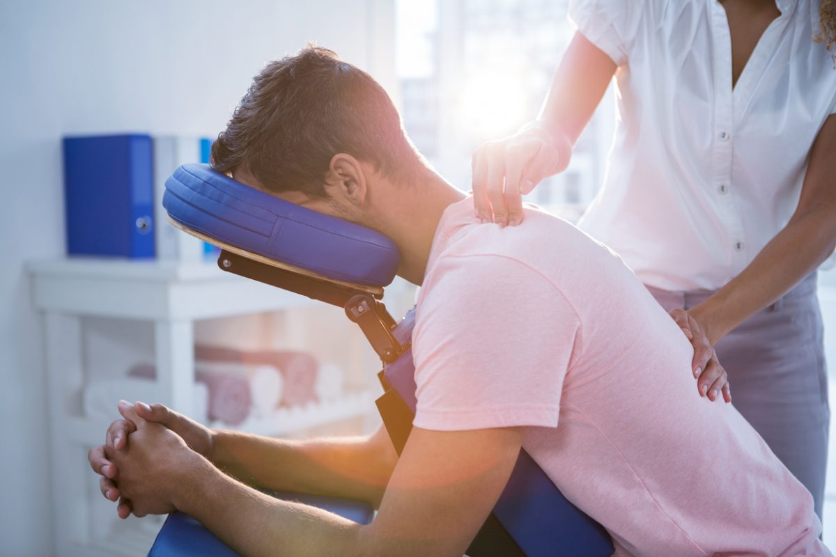 Trinity Rehab therapist treating a patient's lower back with manual therapy