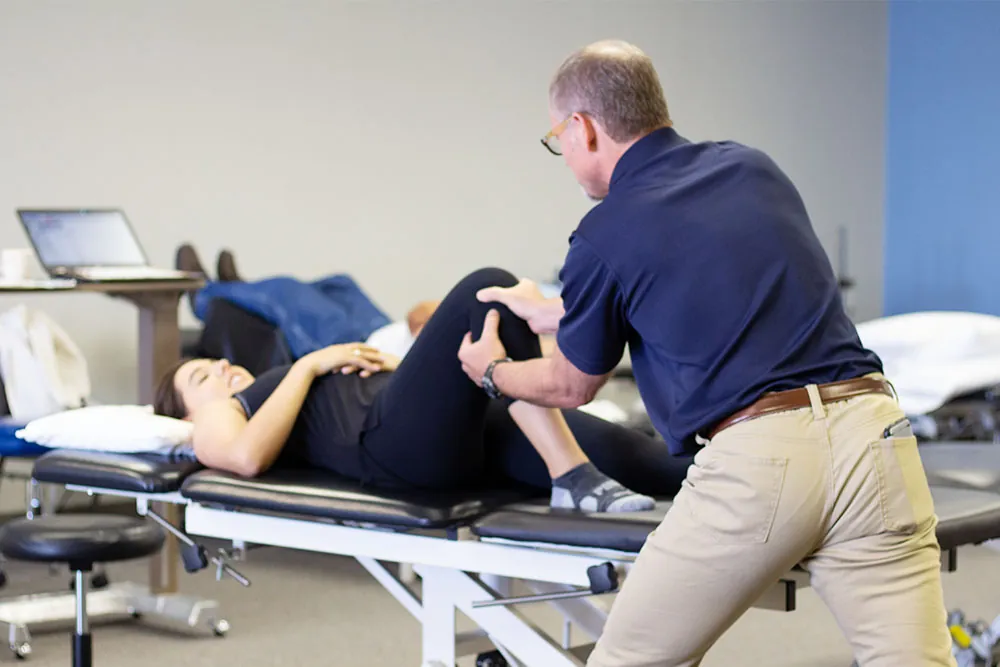 Physical therapist performing manual therapy on a patient's knee