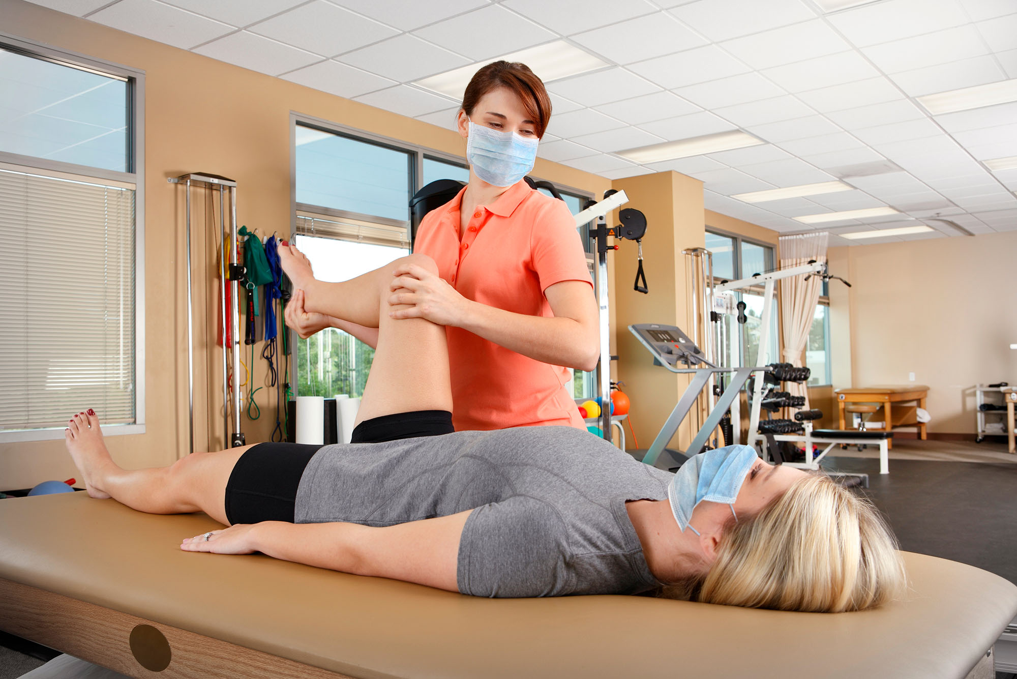 Physical therapist guiding patient through knee recovery exercises