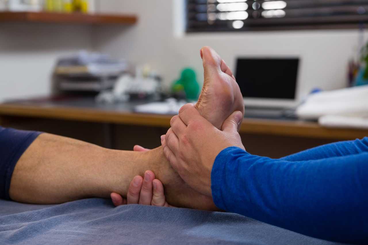 Therapist performing hands-on manual therapy on a patient's foot