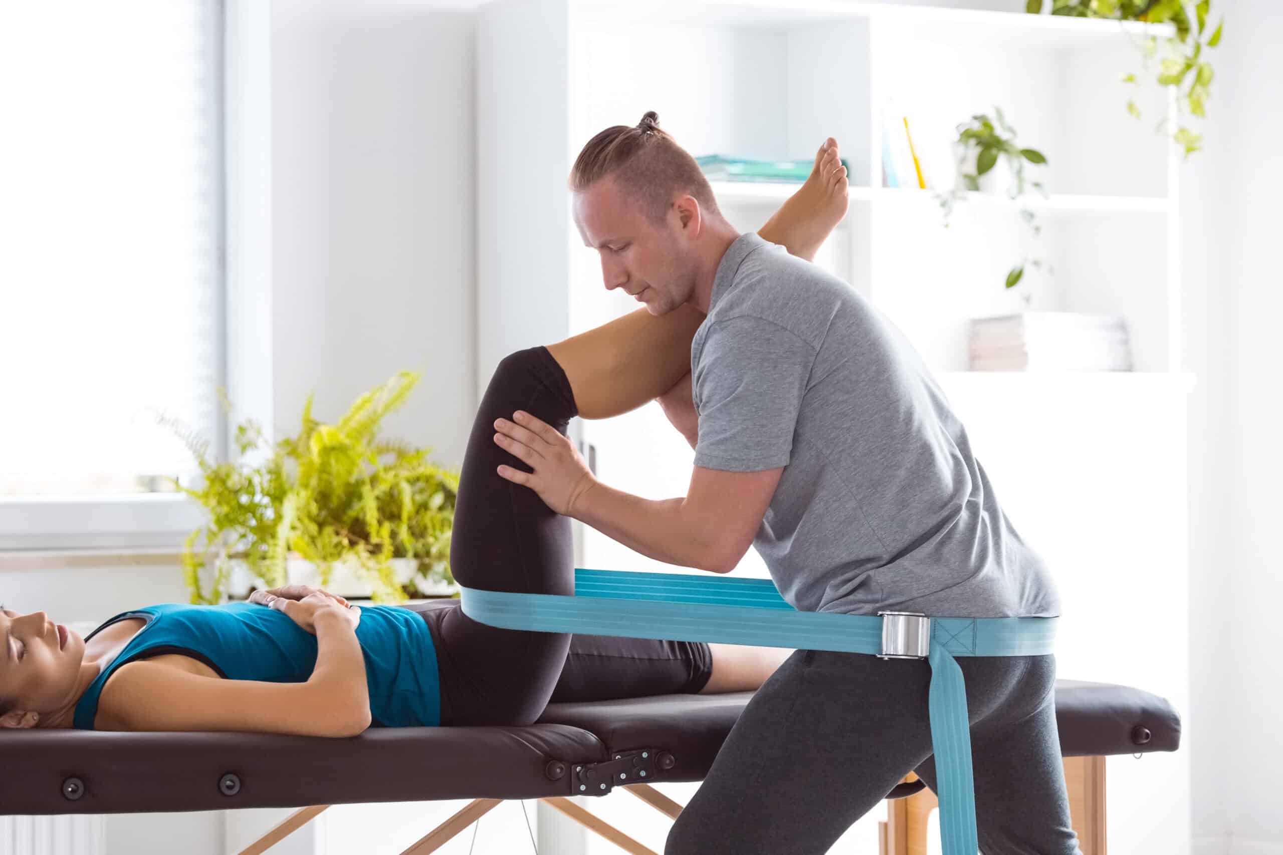 Physical therapist helping a patient with hamstring injury rehabilitation