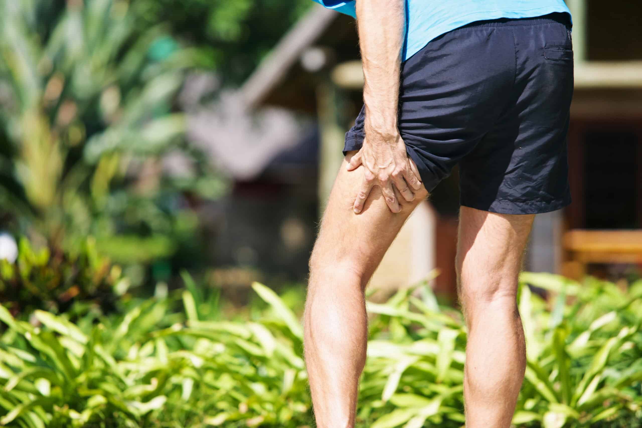Person holding the back of the thigh with hamstring pain