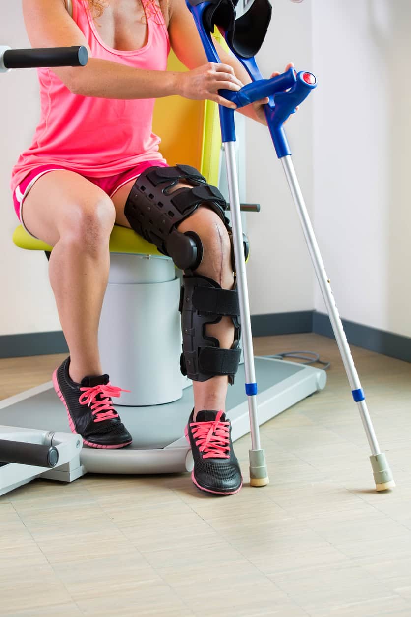 Young woman recovering from surgery wearing a leg brace