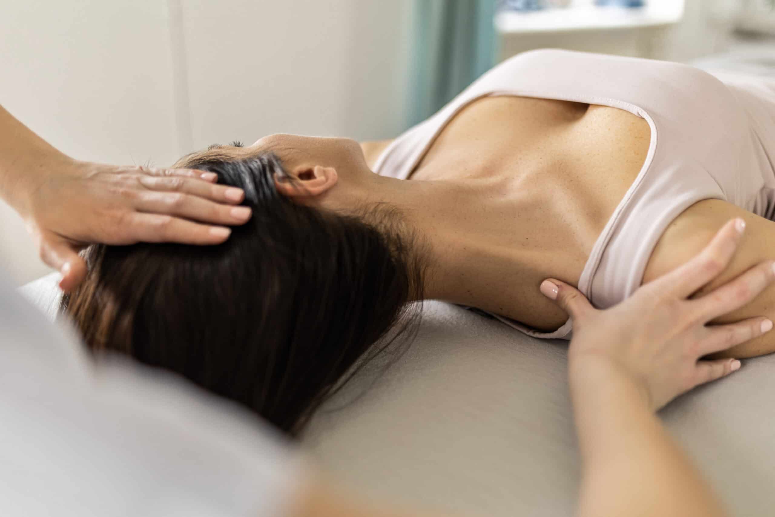 Physical therapist helping patient with neck mobility at Trinity Rehab