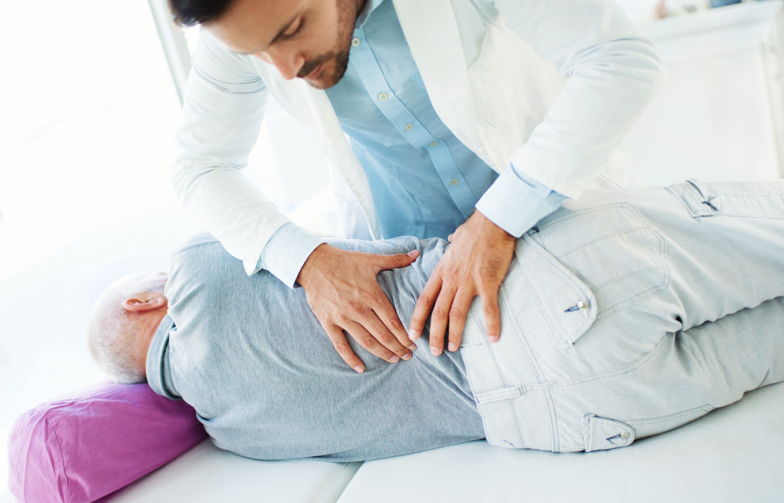 Therapist performing hands-on manual therapy on a patient's lower back